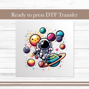 May include: A ready-to-press DTF transfer featuring a cartoon astronaut floating in space with a smiling sun, planets, and stars. The design is colorful and whimsical.