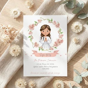 May include: A white invitation card featuring a girl in a white dress, encircled by a floral wreath. The card displays the name "Sofia Ortiz" and event details. The card rests on a wooden surface, complemented by floral decorations.