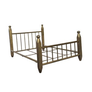 May include: A small, antique-style bed frame in a gold finish. The bed frame has a headboard and footboard with vertical bars and rounded finials. The bed frame is made of metal and has a simple, elegant design.