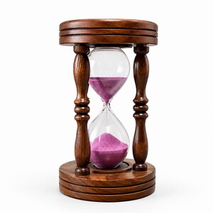May include: An hourglass featuring a dark brown wooden frame with a circular base and top. The clear glass bulb contains vibrant purple sand, with a portion of the sand currently resting in the bottom chamber and a small amount in the top.