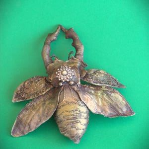 Decorative rhinoceros beetle in the form of a brooch
