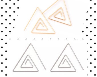 May include: Two pairs of geometric earrings. The top pair is gold-colored, and the bottom pair is silver-colored. Each earring features a triangular frame with an inner spiral design. The earrings are displayed on a white background.