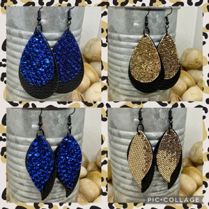 May include: A collage of four pairs of dangle earrings. Each pair features a black leather base with a top layer of either blue glitter, gold glitter, or gold textured material. The earrings hang from black hooks.