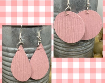 May include: Two pairs of pink leather earrings. One pair is round and the other pair is teardrop shaped.