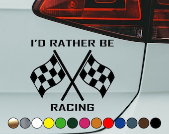 May include: A white car with a black vinyl sticker that says "I'd Rather Be Racing" with two crossed chequered flags.