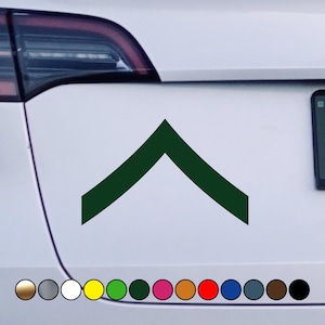 May include: A green chevron sticker on a white car. The chevron is a symbol of rank in the military.
