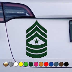 May include: Green and white military rank insignia sticker with five stripes and a star. The sticker is on a white car.