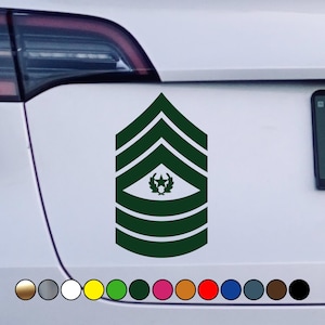 May include: Green and white military rank insignia sticker with five stripes and a star. The sticker is on a white car.