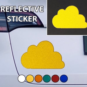 Puede incluir: Una pegatina reflectante de nube amarilla con el texto "REFLECTIVE STICKER" encima. La pegatina está en un coche blanco.