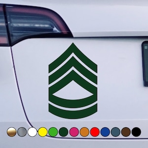 May include: A green and white military rank insignia sticker. The sticker features a chevron design with five stripes and a pointed tip. The sticker is perfect for displaying on a car or other surface.