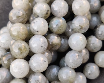 May include: A strand of round, white and grey labradorite beads. The beads have a subtle iridescent sheen.
