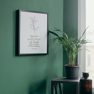Puede incluir: Una impresi&oacute;n enmarcada en negro con fondo blanco y un dibujo simple de una planta. La impresi&oacute;n tiene una cita que dice "Incluso la persona m&aacute;s peque&ntilde;a puede cambiar el curso del futuro." La cita se atribuye a J.R.R. Tolkien.