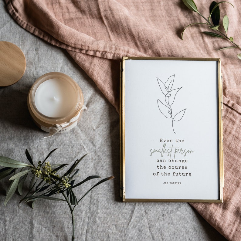 Puede incluir: Una impresi&oacute;n enmarcada en dorado con un dibujo en blanco y negro de una planta. La impresi&oacute;n tiene una cita de J.R.R. Tolkien que dice: "Incluso la persona m&aacute;s peque&ntilde;a puede cambiar el curso del futuro."