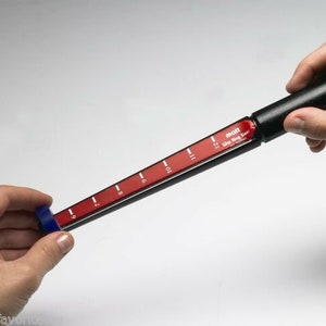 May include: A black and red ring sizer tool with white markings from 6 to 12. The tool is labeled "mott Wax Ring Sizer".