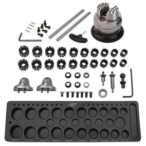 May include: A jewelry making kit with a black tray, a rotating ring mandrel, and various sized ring mandrel inserts. The kit also includes a set of tools for shaping and sizing rings.