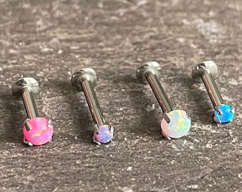 May include: Four silver body jewelry pieces with opal gemstones. The gemstones are pink, white, and blue.