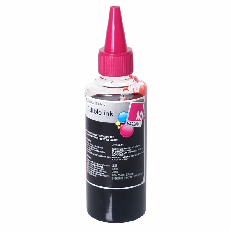 May include: A clear plastic bottle of edible magenta ink with a pink cap. The bottle is labeled "Edible Ink" and "M Magenta".