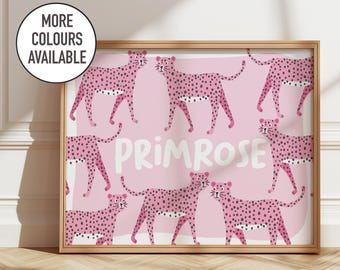 May include: A framed art print featuring a repeating pattern of pink cheetahs with black spots on a light pink background. The word "PRIMROSE" is in white script. A circular graphic in the upper left corner reads "MORE COLOURS AVAILABLE".