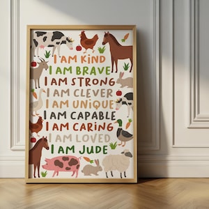 May include: A framed wall art print featuring a collection of farm animals including a cow, horse, pig, sheep, and rabbit, surrounding the text I AM KIND, I AM BRAVE, I AM STRONG, I AM CLEVER, I AM UNIQUE, I AM CAPABLE, I AM CARING, I AM LOVED, I AM JUDE.