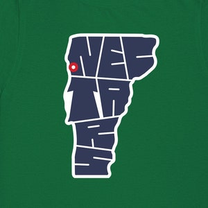 May include: Green t-shirt with a navy blue outline of the state of Vermont. The outline is made up of the words "New" and "England".