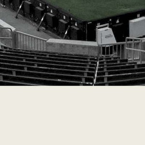 May include: Black and white photo of empty stadium seats with the year 2011 and the names Trey Anastasio, Jon Fishman, Mike Gordon, and Page McConnell.