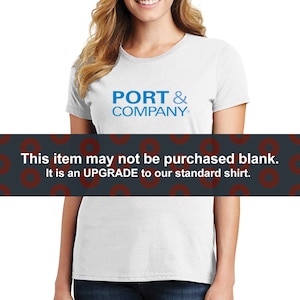 May include: White t-shirt with a blue logo that says "PORT & COMPANY" on the front. The text "This item may not be purchased blank. It is an UPGRADE to our standard shirt." is displayed below the image.