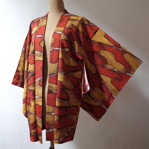 May include: A red and gold patterned Japanese kimono with a long sleeve design.