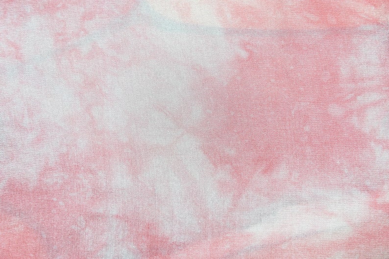 May include: A pink and white tie-dye fabric with a soft, textured surface.