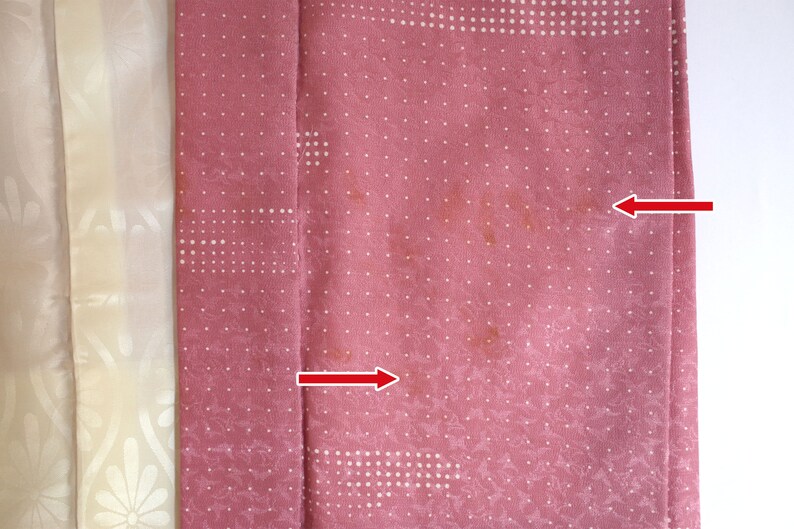 Puede incluir: Una tela rosa con un patr&oacute;n de lunares blancos. Hay dos manchas marrones en la tela.