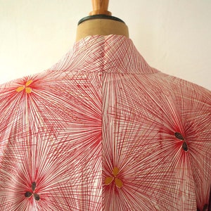 May include: A red and white kimono with a geometric pattern of radiating lines and gold flower accents.
