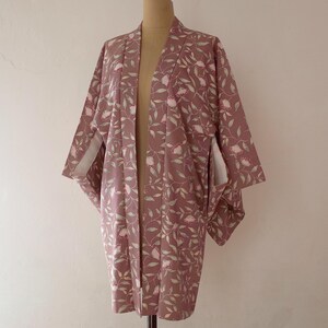 May include: A mauve kimono with a floral pattern of pink flowers and green leaves.