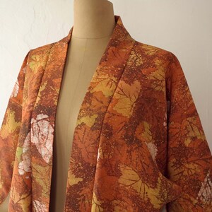 May include: A brown and orange kimono with a leaf pattern. The kimono is made of a soft, lightweight fabric and has a relaxed fit.