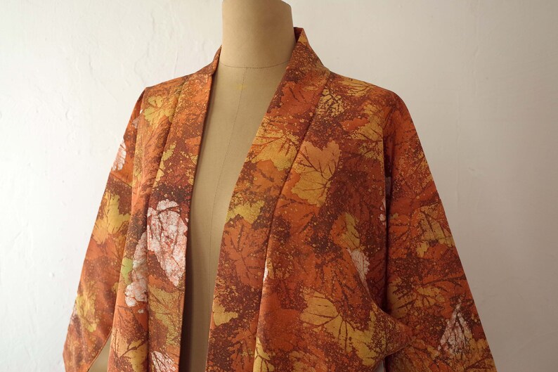 May include: A brown and orange kimono with a leaf pattern. The kimono is made of a soft, lightweight fabric and has a relaxed fit.
