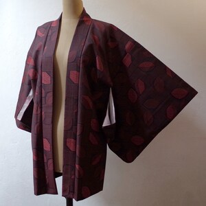 May include: A burgundy and red patterned Japanese kimono with white lining on the sleeves.