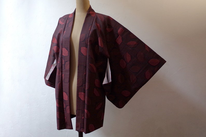 May include: A burgundy and red patterned Japanese kimono with white lining on the sleeves.
