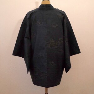 Op de afbeelding: Een donkerblauwe kimono met een subtiel patroon van gouden bladeren. De kimono is gemaakt van een zachte, zijdeachtige stof en heeft een traditioneel Japans ontwerp.