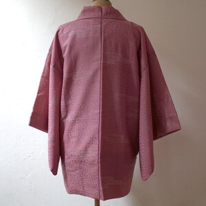 Puede incluir: Un Hanten japon&eacute;s rosa, una chaqueta tradicional corta y sin forro, con un patr&oacute;n geom&eacute;trico blanco.