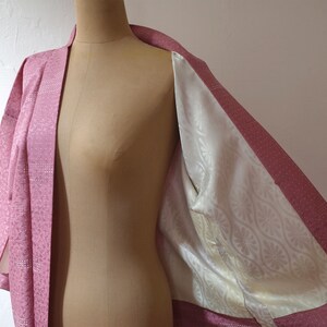 Puede incluir: Un kimono japon&eacute;s rosa con un forro de estampado floral blanco. El kimono est&aacute; hecho de una tela suave y sedosa y tiene un dise&ntilde;o tradicional.