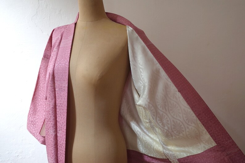 Puede incluir: Un kimono japon&eacute;s rosa con un forro de estampado floral blanco. El kimono est&aacute; hecho de una tela suave y sedosa y tiene un dise&ntilde;o tradicional.