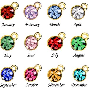 Op de afbeelding: Twaalf gouden bedels met verschillende gekleurde kristallen, elk representatief voor een maand van het jaar. Januari is rood, februari is paars, maart is blauw, april is grijs, mei is groen, juni is roze, juli is rood, augustus is groen, september is blauw, oktober is roze, november is oranje en december is turquoise.