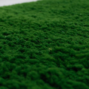 K&ouml;nnte beinhalten: Nahaufnahme eines &uuml;ppigen, gr&uuml;nen Kunstrasens. Die Textur ist weich und &auml;hnelt echtem Gras.