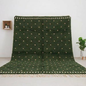 May include: A rectangular area rug in a deep forest green color featuring a repeating pattern of small, light-colored tufted dots across the surface. The rug includes a horizontal border of white rectangular dashes at the top and bottom edges.