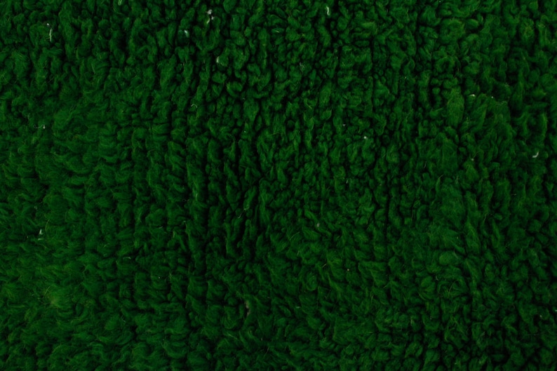 K&ouml;nnte beinhalten: Nahaufnahme einer tiefgr&uuml;nen, flauschigen Stofftextur.