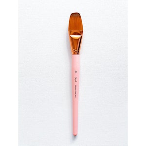 May include: A pink and gold paint brush with a long handle and a flat, angled brush head. The brush is labeled "Dream Come True".
