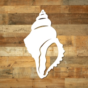 May include: White metal seashell wall decor with a detailed design. The seashell is mounted on a wood background.