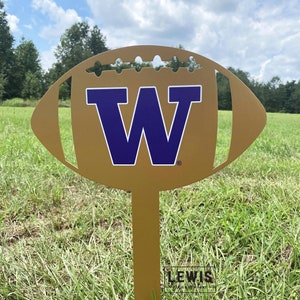 May include: A gold metal football with a purple 