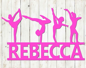 May include: Pink metal silhouette of four gymnasts performing on a balance beam with the name "REBECCA" below.