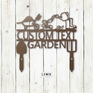 Puede incluir: Estaca de jard&iacute;n de metal con un acabado marr&oacute;n. La estaca presenta una carretilla, un jardinero regando plantas, un caracol y una pala. El texto "CUSTOM TEXT GARDEN" se muestra en la estaca.