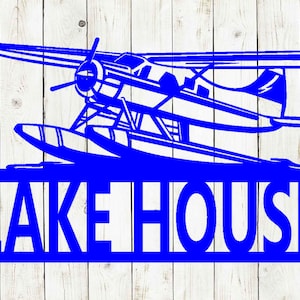May include: Blue metal sign with a silhouette of a seaplane and the text "LAKE HOUSE".