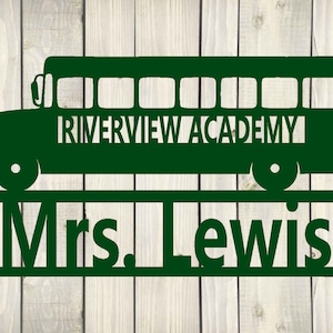 May include: Green metal sign with a school bus silhouette and the text "Riverview Academy" above a nameplate that reads "Mrs. Lewis".